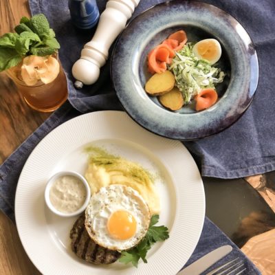 Фирменное блюдо с яйцом и травами на тарелке